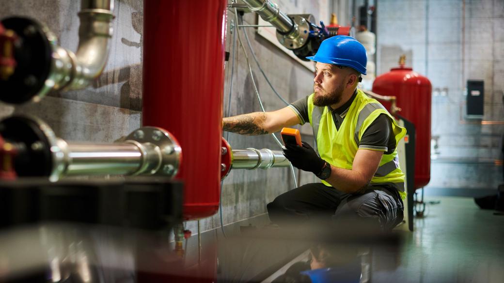 Construction worker installing industrial heating system