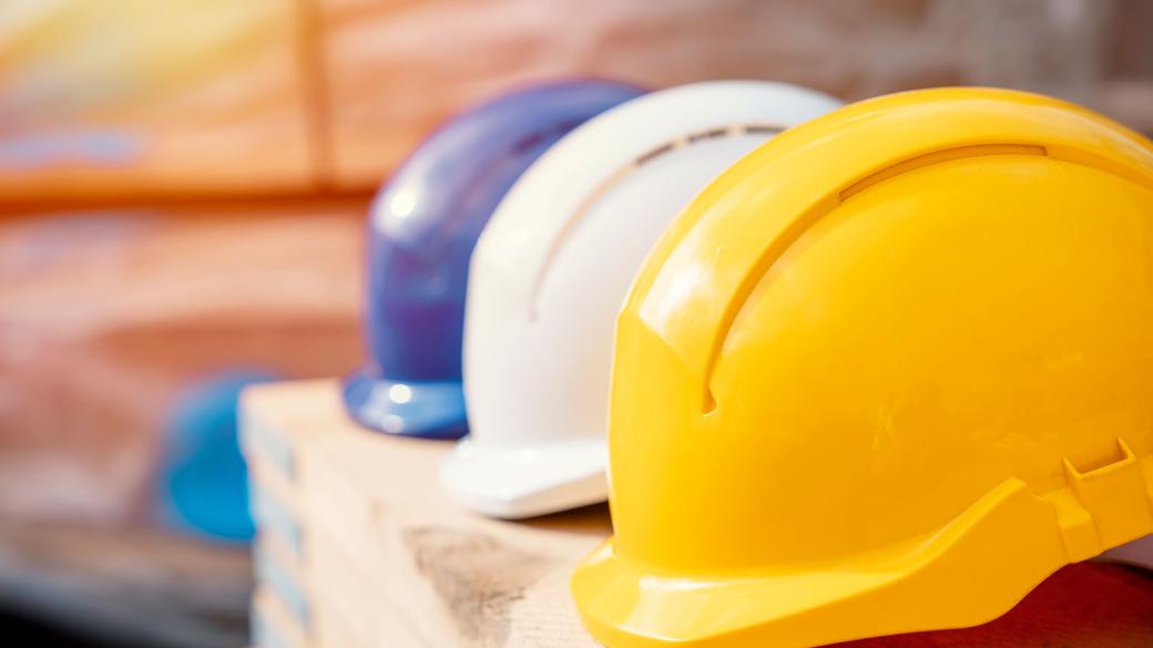 three construction work helmets resting on shelf 