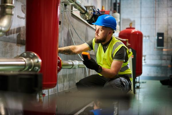 Construction worker installing industrial heating system