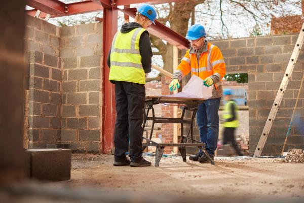 builders checking plans of home extension