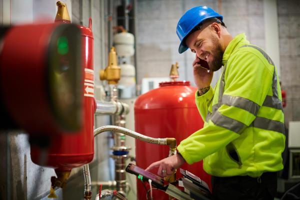 Engineer inspecting mechanical pump in industrial building