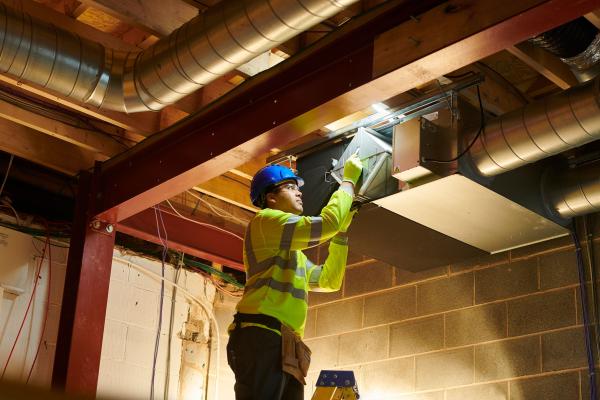 A man servicing an LEV system in a factory