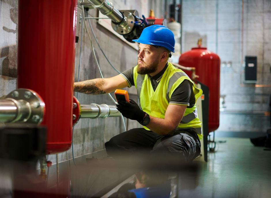 Construction worker installing industrial heating system