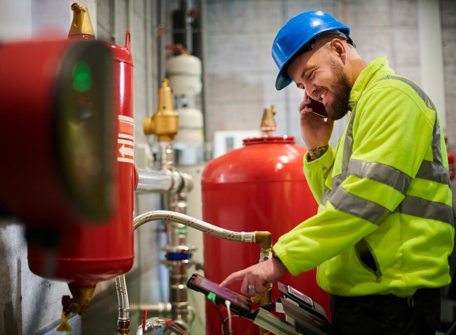 Engineer inspecting mechanical pump in industrial building