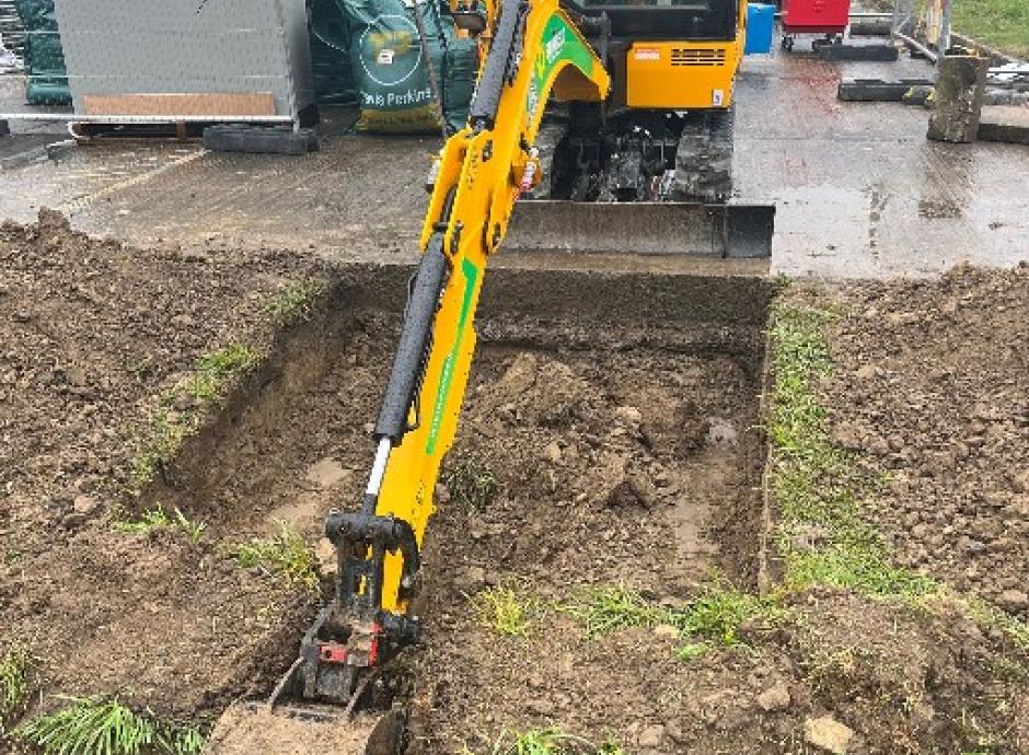 Digger digging trench for electric car charging cables